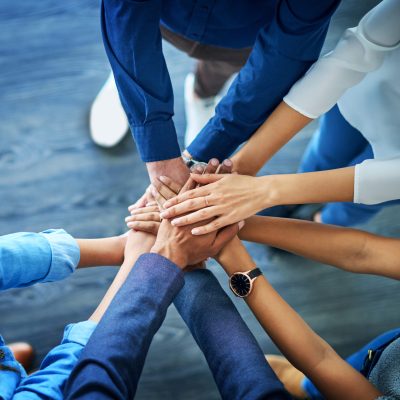 Lets awaken the team spirit. High angle shot of a group unrecognizable businesspeople joining their hands together in unity. High angle shot of a group unrecognizable businesspeople joining their hands together in unity.